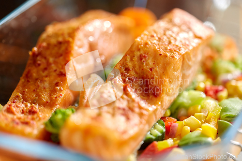 Image of salmon fish in baking dish on kitchen table