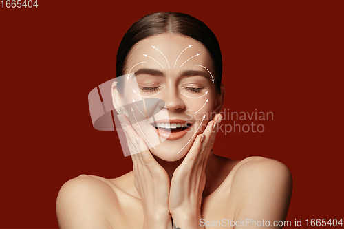 Image of Beautiful female face with lifting up arrows isolated on red background