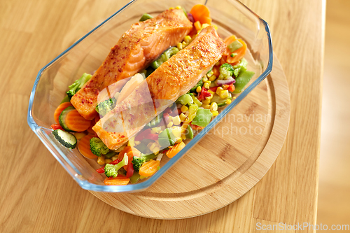 Image of salmon fish in baking dish on kitchen table