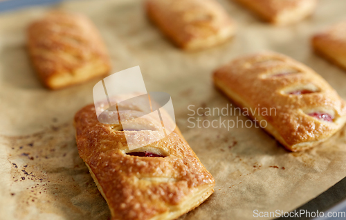 Image of close up of baking tray with jam pies