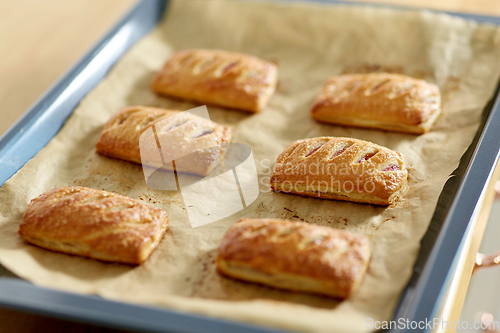 Image of baking tray with jam pies at home kitchen