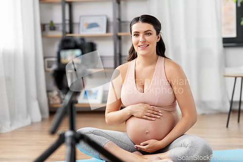 Image of happy pregnant woman blogger recording yoga video