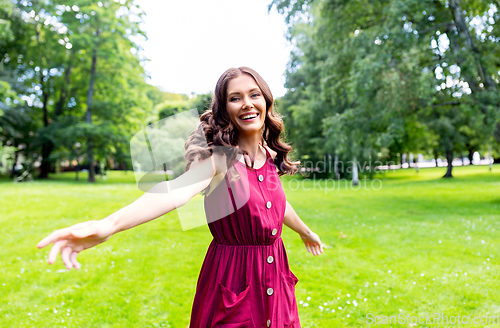 Image of portrait of happy smiling woman at summer park