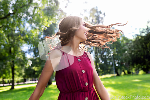 Image of portrait of happy smiling woman at summer park