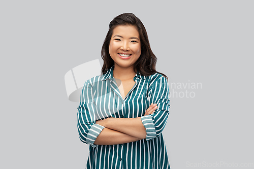 Image of happy asian woman with crossed arms on grey