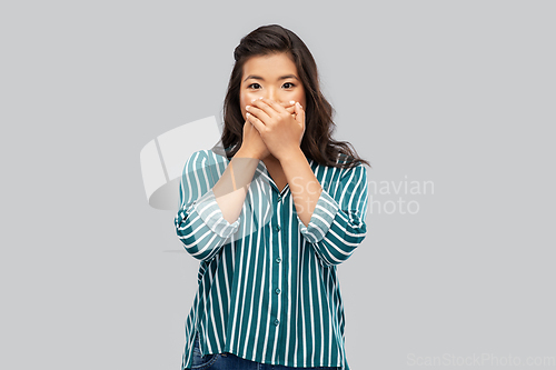 Image of scared asian woman over grey background