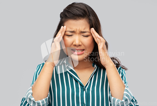 Image of stressed asian woman holding to her head