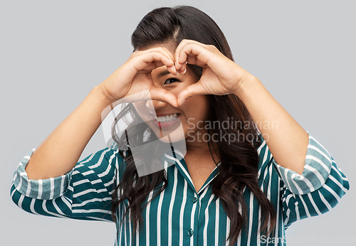 Image of happy asian woman showing hand heart gesture