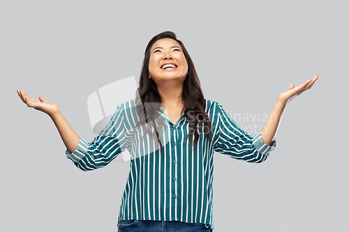 Image of happy smiling asian young woman looking up