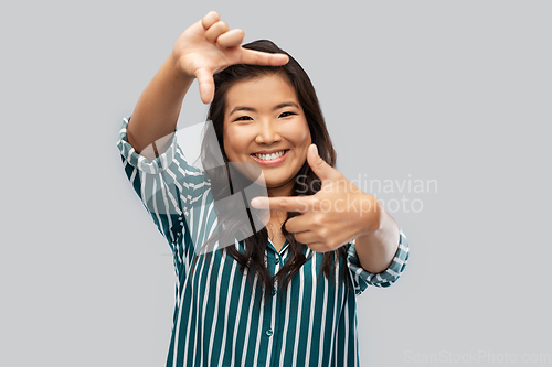 Image of happy asian woman making frame of fingers