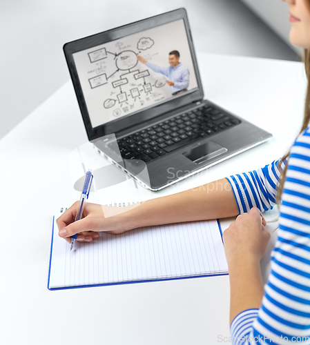 Image of student girl with exercise book, pen and laptop