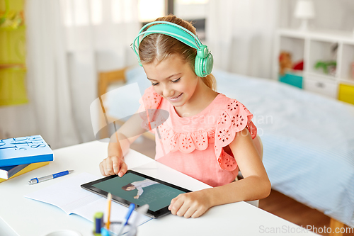 Image of girl in headphones with tablet pc learning at home