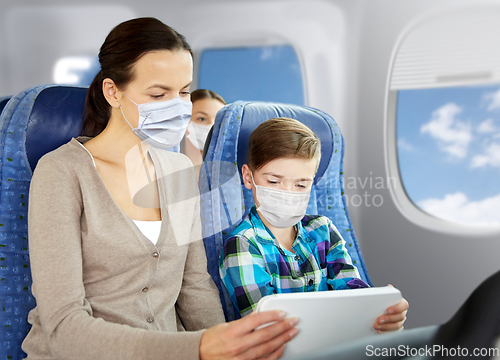 Image of mother and son in masks traveling by plane