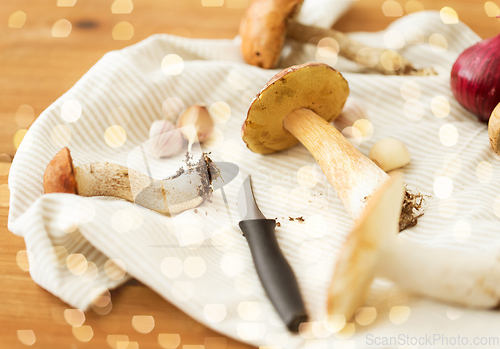 Image of edible mushrooms, kitchen knife and towel