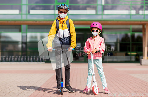 Image of children in masks riding scooters over school