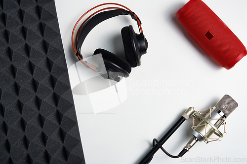 Image of Microphone, headphones and portable stereo speaker on on white background with copy space and acoustic foam panel