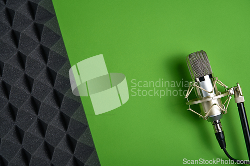 Image of Microphone on green background with copy space and acoustic foam panel