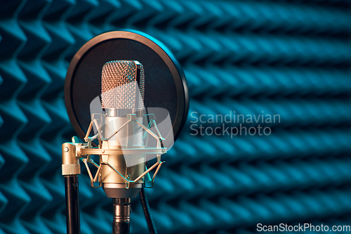 Image of Studio chrome microphone on acoustic foam panel background,