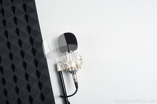 Image of Flat lay of microphone and acoustic foam panel, over white background