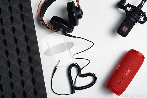 Image of Microphone, headphones and portable stereo speaker on on white background with copy space and acoustic foam panel