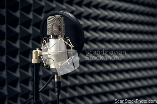 Image of Studio chrome microphone on acoustic foam panel background, shallow depth of field