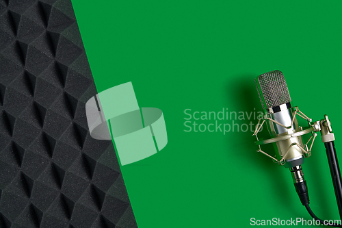 Image of Microphone on green background with copy space and acoustic foam panel