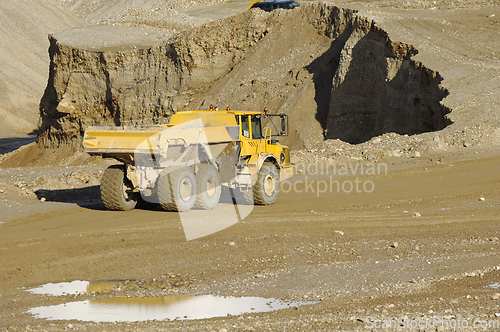 Image of Yellow dump truck working in gravel pit