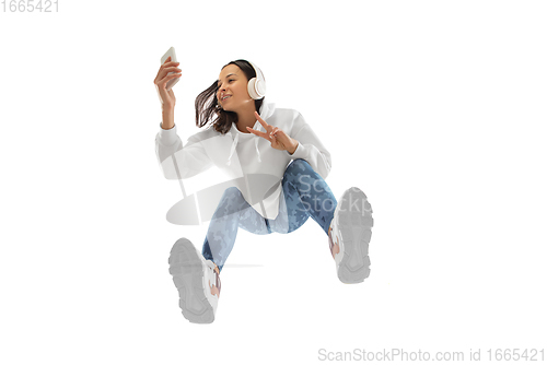 Image of Young stylish woman in modern street style outfit isolated on white background, shot from the bottom