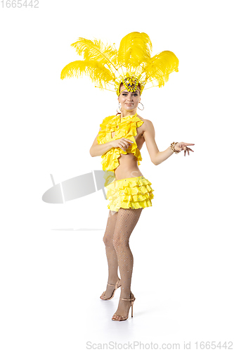 Image of Beautiful young woman in carnival, stylish masquerade costume with feathers dancing on white studio background. Concept of holidays celebration, festive time, dance, party, having fun