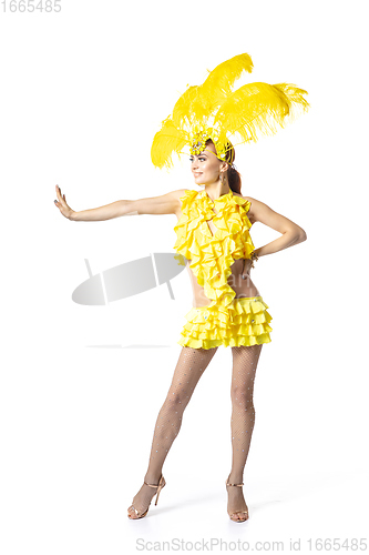 Image of Beautiful young woman in carnival, stylish masquerade costume with feathers dancing on white studio background.