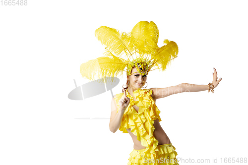 Image of Beautiful young woman in carnival, stylish masquerade costume with feathers dancing on white studio background.