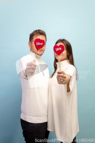 Image of Beautiful couple in love on blue studio background. Valentine\'s Day, love and emotions concept