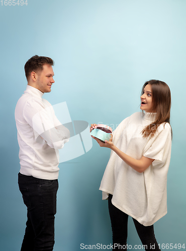 Image of Beautiful couple in love on blue studio background. Valentine\'s Day, love and emotions concept