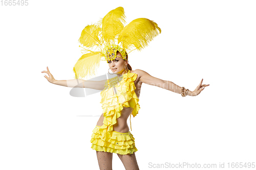 Image of Beautiful young woman in carnival, stylish masquerade costume with feathers dancing on white studio background.