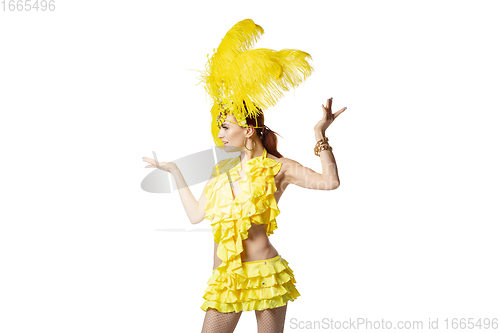 Image of Beautiful young woman in carnival, stylish masquerade costume with feathers dancing on white studio background.
