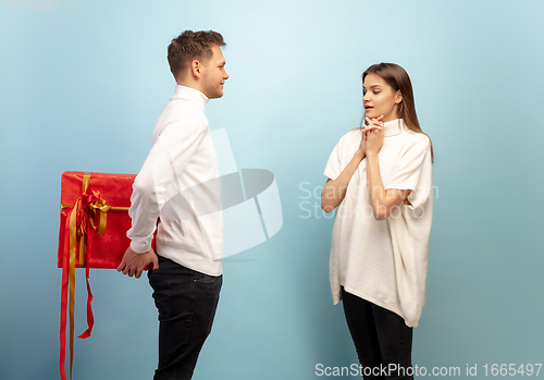 Image of Beautiful couple in love on blue studio background. Valentine\'s Day, love and emotions concept