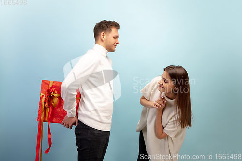 Image of Beautiful couple in love on blue studio background. Valentine\'s Day, love and emotions concept