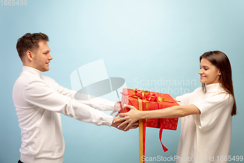 Image of Beautiful couple in love on blue studio background. Valentine\'s Day, love and emotions concept