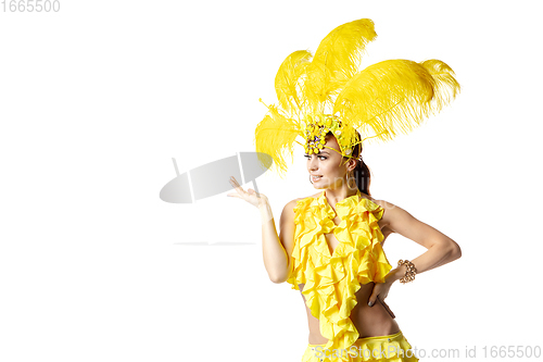 Image of Beautiful young woman in carnival, stylish masquerade costume with feathers dancing on white studio background.