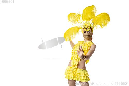 Image of Beautiful young woman in carnival, stylish masquerade costume with feathers dancing on white studio background.