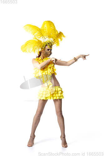 Image of Beautiful young woman in carnival, stylish masquerade costume with feathers dancing on white studio background.