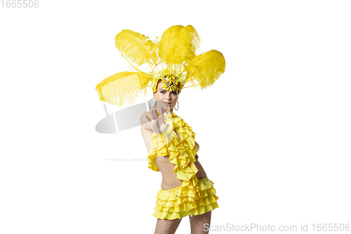 Image of Beautiful young woman in carnival, stylish masquerade costume with feathers dancing on white studio background.