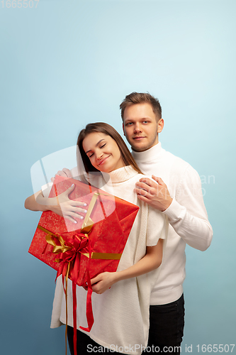 Image of Beautiful couple in love on blue studio background. Valentine\'s Day, love and emotions concept