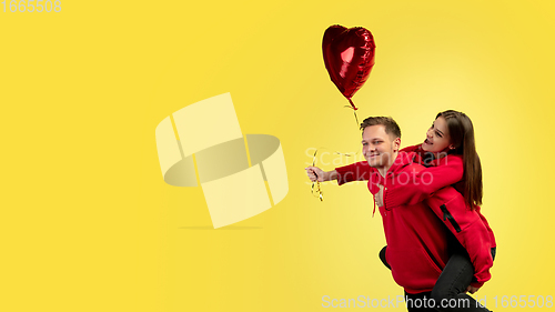 Image of Beautiful couple in love on yellow studio background. Valentine\'s Day, love and emotions concept