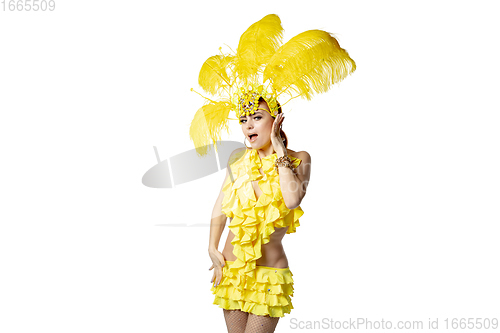 Image of Beautiful young woman in carnival, stylish masquerade costume with feathers dancing on white studio background.