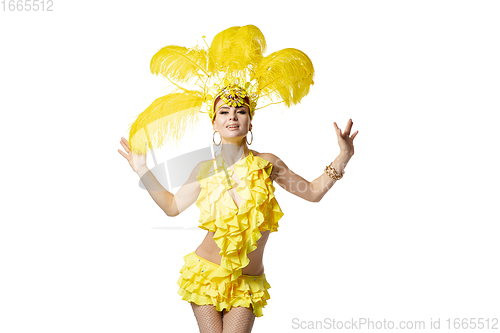 Image of Beautiful young woman in carnival, stylish masquerade costume with feathers dancing on white studio background.