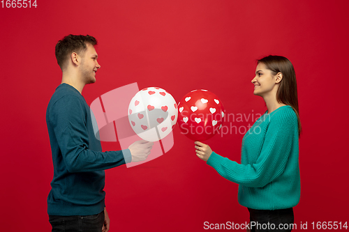 Image of Beautiful couple in love on red studio background. Valentine\'s Day, love and emotions concept