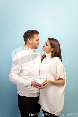 Image of Beautiful couple in love on blue studio background. Valentine\'s Day, love and emotions concept