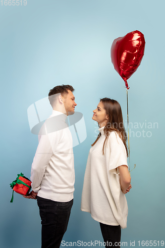 Image of Beautiful couple in love on blue studio background. Valentine\'s Day, love and emotions concept