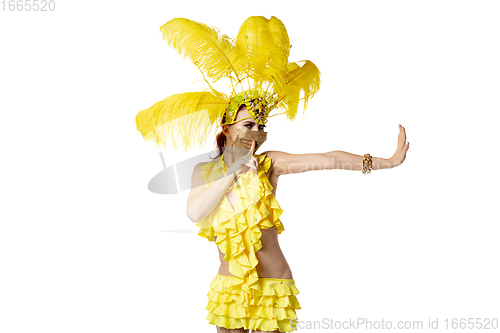 Image of Beautiful young woman in carnival, stylish masquerade costume with feathers dancing on white studio background.